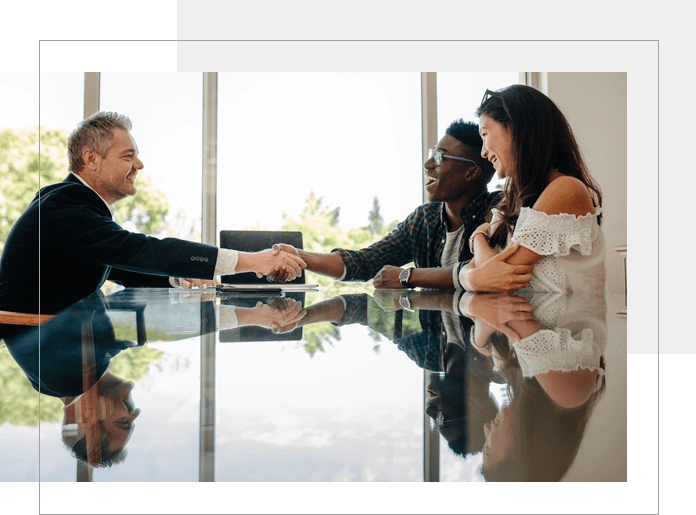 A group of people sitting at a table shaking hands.